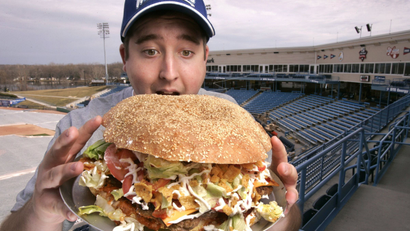 Josh Kowalczyk, an intern with the West Michigan Whitecaps, in Comstock Park, Mich. poses for a photo March 24, 2009. The $20 burger will feature a sesame-seed bun made from a pound of dough, five 1/3-pound beef patties, five slices of cheese, nearly a cup of chili and liberal doses of salsa and corn chips. (AP Photo/The Grand Rapids Press, Rex Larsen)