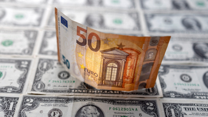 A Euro banknote is displayed on U.S. Dollar banknotes.