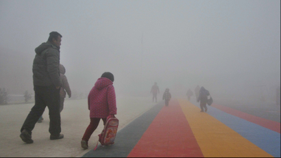 Parents walk primary school students to school amid thick haze in Chiping county, Shandong province January 16, 2015