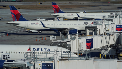 Several Delta airplanes are pictured at gates outside the airport.