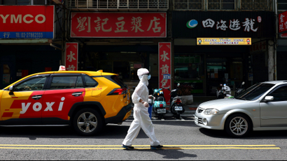 A person dressed in protective suit walks down a street following the recent surge of coronavirus disease (COVID-19) infections in Taipei, Taiwan, June 2, 2021. REUTERS/Ann Wang TPX IMAGES OF THE DAY