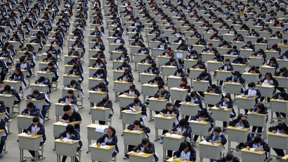 Students take an examination on an open-air playground at a high school in Yichuan