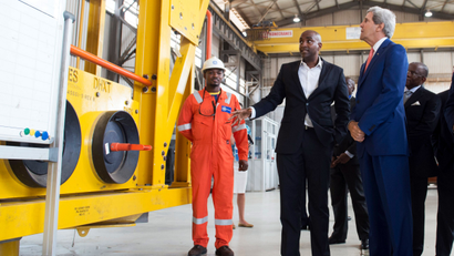 U.S. Secretary of State John Kerry (C) walks alongside Jay Ireland (R), President and CEO of General Electric Africa, as he tours the General Electric (GE) Sonils compound at the port of Luanda May 4, 2014.