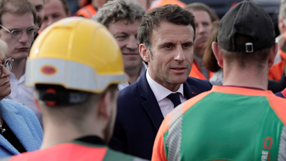 Emmanuel Macron is surrounded by a crowd of manual workers in northern France.
