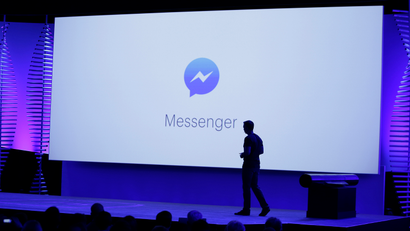 David Marcus, Facebook Vice President of Messaging Products, watches a display showing new features of Messenger during the keynote address at the F8 Facebook Developer Conference Tuesday, April 12, 2016, in San Francisco. Facebook says people who use its Messenger chat service will soon be able to order flowers, request news articles and talk with businesses by sending them direct text messages. At its annual conference for software developers, Zuckerberg said the company is releasing new tools that businesses can use to build "chat bots," or programs that talk to customers in conversational language. (AP Photo/Eric Risberg)