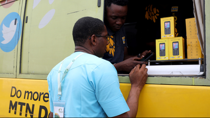 A customer speaks with a vendor through the window of a bus belonging to MTN.