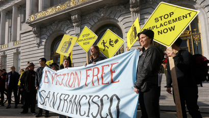 Members of the Housing Rights Committee of San Francisco and other activists protest outside of City Hall in San Francisco, Tuesday, Jan. 21, 2014. San Francisco officials are set to vote on a plan to start regulating employee shuttles for companies like Google, Facebook and Apple, charging a fee for those that use public bus stops and controlling where they load and unload. Private shuttle buses have created traffic problems, blocking public bus stops during peak commute hours.