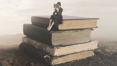 Surreal image of a woman reading sitting on top of a book