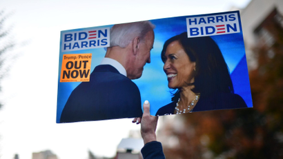 An activist holds a sign showing Democratic presidential nominee Joe Biden and vice presidential nominee Kamala Harris in Philadelphia
