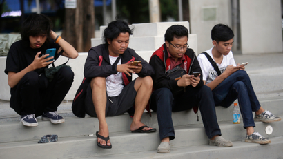 In this Monday, July 18, 2016 photo, people gaze at their smartphones as they play "Pokemon Go" in Jakarta, Indonesia. Indonesian authorities banned the playing of "Pokemon Go" from the presidential palace on Wednesday, July 20, 2016, as they voiced worries that the game could be a security risk. (AP Photo/Tatan Syuflana)