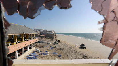 A general view through a broken glass shows government forces patrolling on Lido beach following an attack at beachside restaurant Beach View Cafe in Somalia's capital Mogadishu, January 22, 2016.