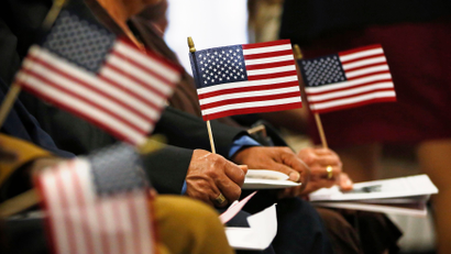 Immigrants hold U.S. flags during naturalization ceremony in New York