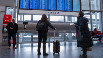 Travelers check the departure board at O'Hare International Airport in Chicago
