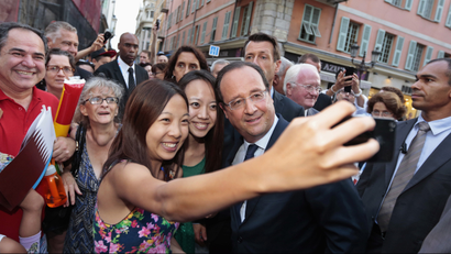 Chinese tourists take a photo of themselves with France's President Francois Hollande ahead of the opening ceremony of the 7th Francophone Games in Nice September 7, 2013. REUTERS/Eric Gaillard