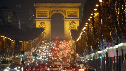 Christmas holiday lights decorate trees along the Champs Elysees with its Arc de Triomphe, in Paris November 20, 2014.