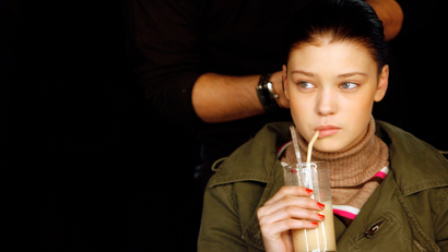 A model drinks a smoothie as she gets ready before Gharani Strok's Autumn/Winter 2007 show at London Fashion Week