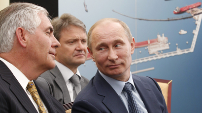 Russian President Vladimir Putin, right, and Exxon Mobil Corp. CEO Rex Tillerson, left, attend a signing ceremony of an agreement between state-controlled Russian oil company Rosneft and Exxon Mobil corporation at the Black Sea port of Tuapse, southern Russia, Friday, June 15, 2012. In the background is Krasnodar region governor Alexander Tkachev.