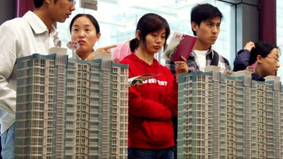 Chinese visitors look at model residential apartment buildings at a house fair in Nanjing city, east Chinas Jiangsu province, 8 April 2008. Chinese government on October 22 stepped in to bolster the ailing real estate market by lowering transaction taxes, reducing down payments and lowering mortgage rates. But analysts said the measures may not hold back price corrections because the current prices have surged far out of reach of many buyers. The Ministry of Finance and the central bank announced that property purchase tax would be lowered to 1 per cent for people buying their first home if it is smaller than 90sqm. The previous rate was 3 per cent, with those buying houses smaller than 140sqm paying 1.5 per cent. The new rate will be effective from November 1. For people buying their first home, the down payment ratio will be lowered to 20 per cent, and banks will be allowed to charge as low as 70 per cent of benchmark lending rates for such mortgages. Both measures are effective next Monday (October 27).(Imaginechina via AP Images