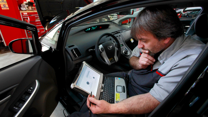 FILE - In this Feb. 9, 2010 file photo, master diagnostic technician Kurt Juergens, of Foxborough, Mass., uses a laptop computer to diagnose and repair the brake system on a 2010 Toyota Prius in the repair shop of a Toyota dealership, in Norwood, Mass. A pair of hackers maneuvered their way into the computer systems of a 2010 Toyota Prius and 2010 Ford Escape through a port used by mechanics. The hackers showed that they could slam on the brakes at freeway speeds, jerk the steering wheel or even shut down the engine, all from their laptop computers. The work demonstrates vulnerabilities with the growing number of car computers, about 20 on older models and up to 70 on sophisticated luxury cars.