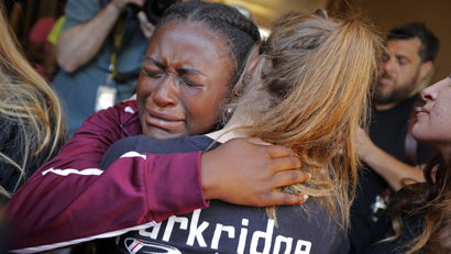 Marla Eveillard, 14, cries as she hugs friends before the start of a vigil at the Parkland Baptist Church, for the victims of the Marjory Stoneman Douglas High School shooting.