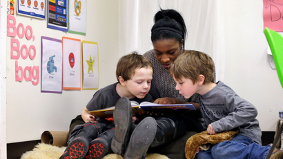 In this photo taken Feb. 12, 2016, assistant teacher D'onna Hartman, reads to Frederick Frenious, left, and Gus Saunders at the Creative Kids Learning Center, a school that focuses on pre-kindergarten for 4- and 5-year-olds, in Seattle.