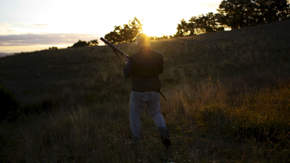 A hunter walks at sunrise during the first day of the Italy hunting season in Castell'Azzara, Tuscany, central Italy, September 20, 2015. The number of hunters in Italy has been decreasing, from 1,701,853 in 1980 to 751.876 in 2007, with a percentage reduction of 55.8%, according to the latest available numbers from the national statistics bureau ISTAT. REUTERS/Max Rossi
