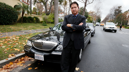 Transportation app Uber driver Shuki Zanna, 49, poses in front of his limousine in Beverly Hills, California, December 19, 2013. Uber has entered more than 60 markets, ranging from its hometown of San Francisco to Berlin to Tokyo. Leaked financials in December indicate that the company, which began connecting passengers with drivers of vehicles for hire about 3-1/2 years ago, is generating $200 million a year in revenue beyond what it pays to drivers. Photo taken December 19, 2013.