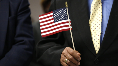 An immigrant holds a U.S. flag during a naturalization ceremony in New York