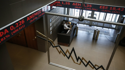 An employee of the Athens' Stock Exchange stands behind a reception desk in Athens, Greece.