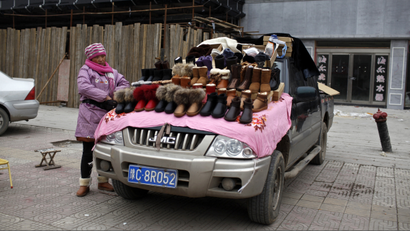 A vendor stands beside her shoes stall atop her car at the business area of Jiaozuo, China's central Henan province, December 20, 2012. Economists who believe China's rebalancing is underway say population trends and income growth are only part of what will trigger a sustained increase in consumption's share of the overall economy. Rising disposable incomes coincide with a change in psychology among younger consumers - a shift that means when it comes to money and spending they are decidedly not their parents. Picture taken December 20, 2012. To match Insight CHINA-CONSUMER/2020 REUTERS/Aly Song