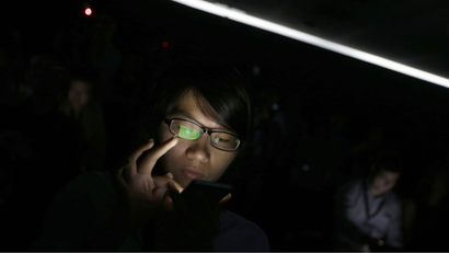A journalist checks her iPod at Apple Inc's announcement event in Beijing, September 11, 2013. Apple Inc's millions of Chinese fans will celebrate the near-simultaneous launch of the latest iPhone in China and the United States, but one group will have little to cheer - the smugglers. An early launch of Apple's latest smartphone in China is expected to stifle a thriving grey market worth billions of dollars a year built around smuggling from Hong Kong, where in the past the U.S. tech giant's gadgets have gone on sale months before they reach official channels in the mainland.