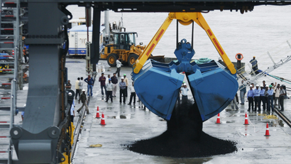 A crane unloads coal from a ship during the inauguration ceremony of Adani Cargo Port at Dahej