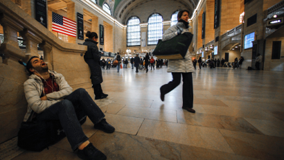 A commuter takes a nap before his train departs from the Grand Central Station in New York