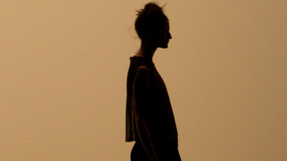 A side-profile silhouette of a woman