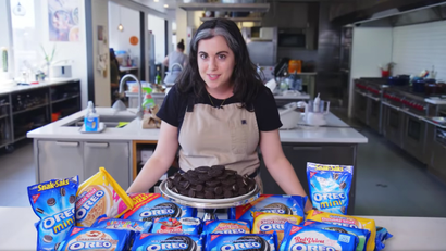 Bon Appétit test kitchen's Claire Saffitz stands in front of various Oreo cookie packages.