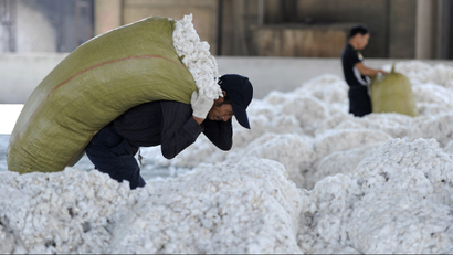 A worker carries a sack of cotton at a cotton purchasing station in China's Anhui province.