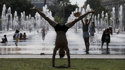 A man stretches near fountains in Nice as a heatwave hits much of the country