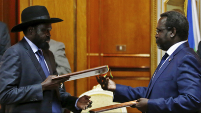 South Sudan's rebel leader Riek Machar (R) and South Sudan's President Salva Kiir exchange signed peace agreement documents in Addis Ababa in May 2014.