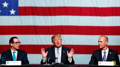 Treasury Secretary Steve Mnuchin, left, and Boeing CEO Dennis Muilenburg, right, listens as President Donald Trump speaks during a roundtable discussion on tax policy at the Boeing Company, Wednesday, March 14, 2018, in St. Louis.