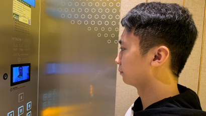 A staff member has his face scanned at an elevator during a demonstration to the media at Alibaba's FlyZoo hotel in China