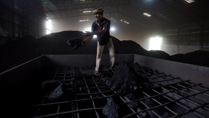A labourer works inside a coal yard on the outskirts of Ahmedabad, India.