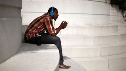 A man with Beats headphones listens to music on an iPhone in Los Angeles