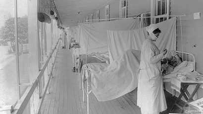 A nurse takes the pulse of a patientin the influenza ward at Walter Reed Hospital during the Spanish Flu pandemic
