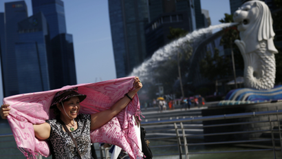 Tourists posing for photos at the Merlion Park in Singapore, 21 July 2014. According to a report by the Singapore Tourism Board (STB) released on 21 July 2014, Chinese tourists arrivals dived 14 per cent year-on-year to 557,000 due to the on-going effects of China's new tourism law implemented in October 2013. Despite the drop in arrivals, Chinese visitors' spending is still the highest compared to other countries generating 800 million Singapore dollars (SGD) (476.5 million euros), compared to Indonesia's SGD 658 million (391.0 million euros) and India's SDG 284 million (169.2 millions euros) in the first quarter of the year.