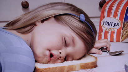 girl sleeping with head on a piece of bread