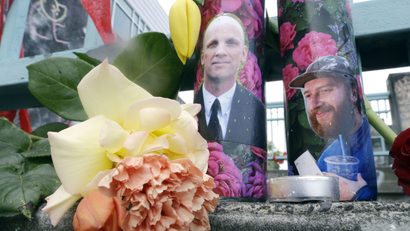 Candles with photos of Taliesin Namkai-Meche, right, and Ricky Best
