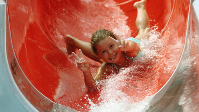 A girl enjoys speeding down a water chute at Kongressbad public swimming bath in Vienna.