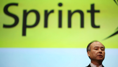 Softbank founder and chief executive Masayoshi Son speaks in front of a logo of U.S. telecom company Sprint during a news conference in Tokyo, Tuesday, Nov. 4, 2014. Softbank's quarterly profit nearly tripled as gains from the IPO of Chinese e-commerce company Alibaba offset losses at U.S. mobile carrier Sprint. (AP Photo/Eugene Hoshiko)