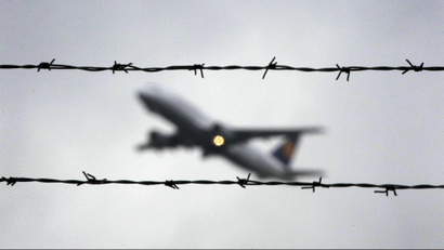 A plane takes off at the Duesseldorf International Airport behind barbed wire on Tuesday Nov. 23,2010.