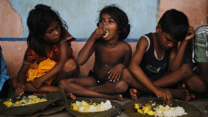 Children eat their lunch in a free meal centre at the cyclone-hit Gopalpur village, in Ganjam district in the eastern Indian state of Odisha October 14, 2013.
